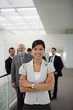 Femme d'affaires souriante devant trois hommes en costume