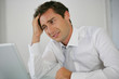 Portrait d'un homme stressé devant un ordinateur portable