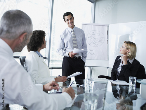 Photo: Group of office workers in a boardroom presentation Group of office workers in a boardroom presentation