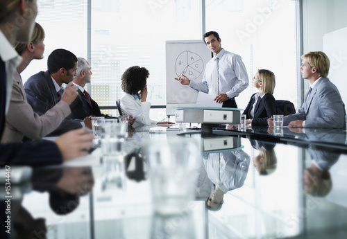Photo: Group of office workers in a boardroom presentation Group of office workers in a boardroom presentation