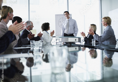 Photo: Group of office workers in a boardroom presentation Group of office workers in a boardroom presentation