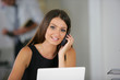 Femme d'affaires souriante téléphonant evant un ordinateur Femme d'affaires souriante téléphonant evant un ordinateur