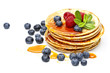 small pancakes topped with honey, raspberries and bilberries