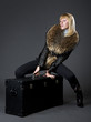 The stylish girl sitting over the trunk