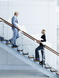 Male and female office workers on staircase holding arrow signs