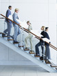 Male and female office workers on staircase holding arrow signs