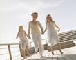 Woman and girls holding hands and smiling outdoors
