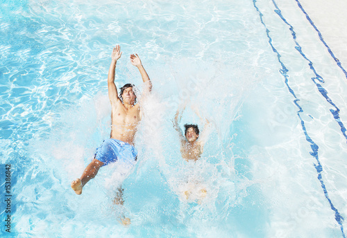Photo: Two boys falling backwards into pool Two boys falling backwards into pool