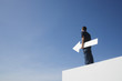 Man outdoors on wall with blank arrow