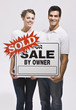 Couple Holding For Sale By Owners Sign