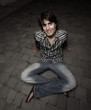Photo: Young adult sitting on the ground Young adult sitting on the ground