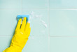 Hand with sponge, washing bathroom's wall