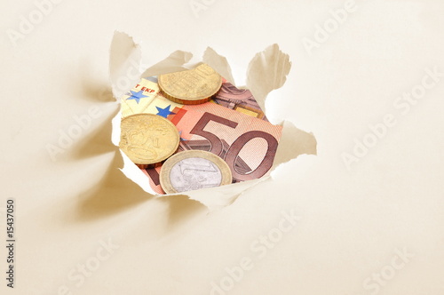 Photo: euro money behind hole in paper euro money behind hole in paper