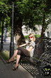 a young girl sits on a bench