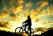 Silhouette of a standing biker. Sunset.