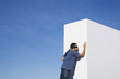 Blindfolded man reaching wall outdoors