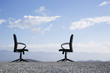 Two office chairs on a terrain full of pebbles
