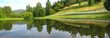 Attractive white horse fence and reflection in the trout pond