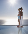 A man and woman back to back by tranquil waters