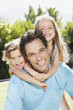 A father with his two young daughters lifted up on his back