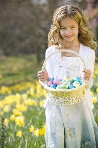 Photo: Young Girl Holding Basket Full of Easter Eggs Smiling Young Girl Holding Basket Full of Easter Eggs Smiling