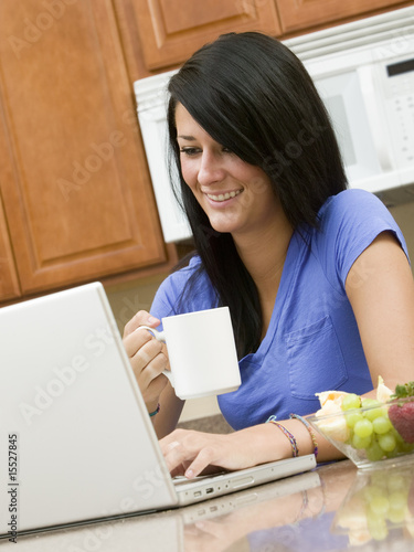 Photo: A beautiful woman on her computer while having breakfast A beautiful woman on her computer while having breakfast