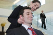 Businesswoman massaging stressed executive's head.