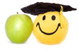 Happy grad toy & a green apple isolated on a white background
