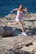 Woman running/jumping by the sea