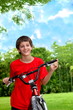 Teenager boy with bicycles in summer park