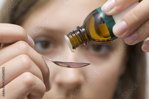 Photo: Dripping herbal essence of a vial over a spoon Dripping herbal essence of a vial over a spoon