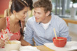 Teenage boy and girl sharing noodle in cafeteria