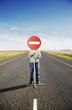 A man holding a sign in the middle of the road