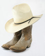 Worn cowboy boots with straw hat Worn cowboy boots with straw hat