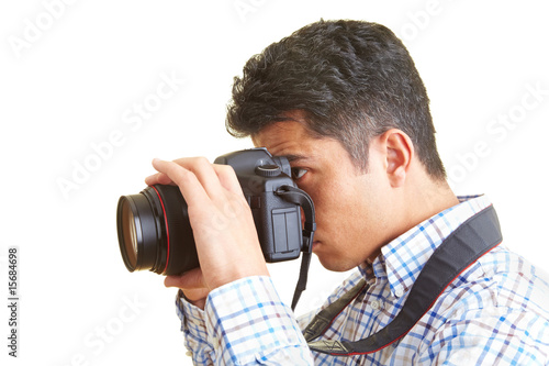 Mann schaut durch eine digitale Spiegelreflexkamera Mann schaut durch eine digitale Spiegelreflexkamera
