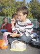 Students outside of school eating and writing