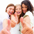 Closeup portrait of happy young friends showing thumbs up