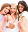 Closeup portrait of happy young friends showing thumbs up