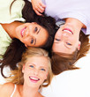 Portrait of happy young friends lying together on white