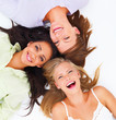 Portrait of happy young friends lying together on white