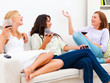 Three young female friends sitting with drinks and having fun