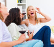 Young female friends sitting with drinks and having fun