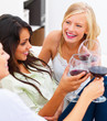Closeup of three happy young female friends toasting wine