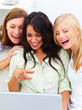 Young women laughing in front of a laptop