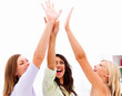Happy young girls raising hands together on white background
