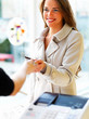 Happy young woman paying through credit card