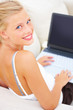 Happy blond woman using a laptop