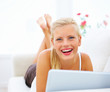 Laughing blond woman using a laptop