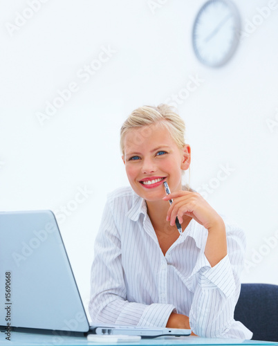 Photo: Beautiful business woman Smiling by laptop at desk Beautiful business woman Smiling by laptop at desk