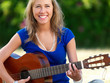 Happy young woman playing guitar